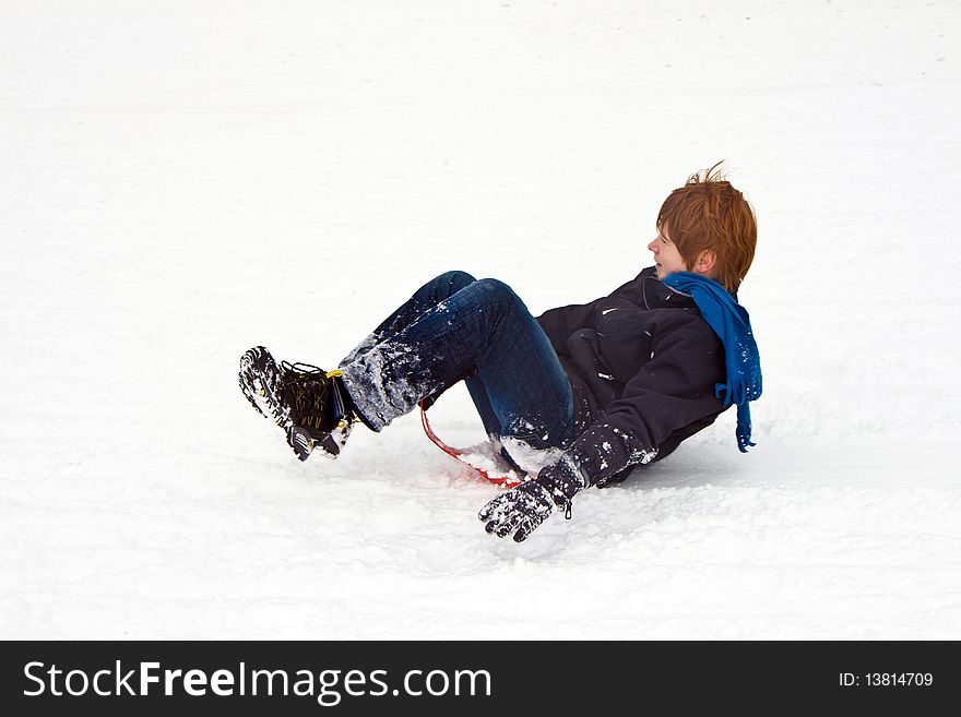 Children are sledding down the hill in snow, white winter