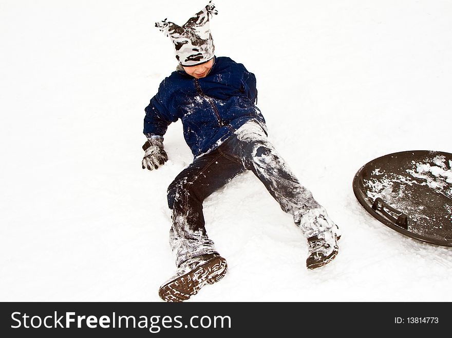 Children are sledding down the hill in snow, white winter