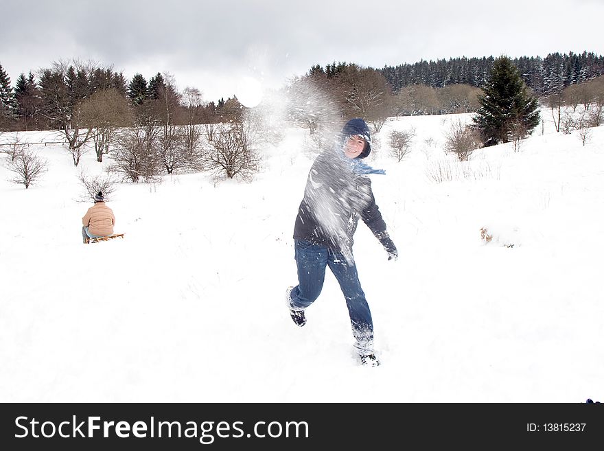 Child Is Fighting With Snowballs In Winter