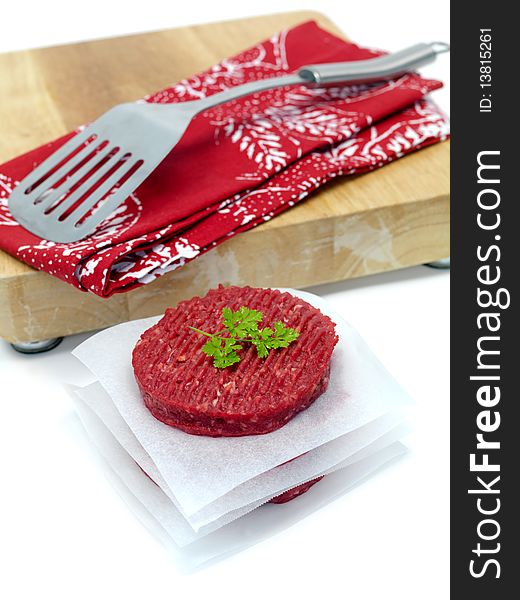 Burger patties isolated on a chopping board. Burger patties isolated on a chopping board