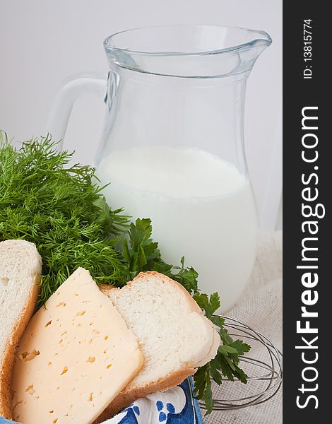 Milk, cheese, bread and seasoning (a parsley, fennel) with a jug of milk. Milk, cheese, bread and seasoning (a parsley, fennel) with a jug of milk