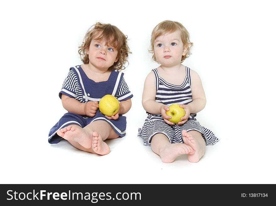 Two toddler girls with green apples over white