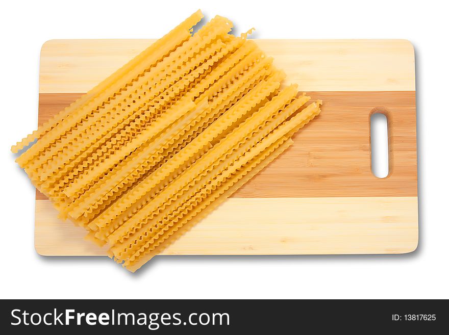 Yellow spaghetti on cutting board over white. Yellow spaghetti on cutting board over white