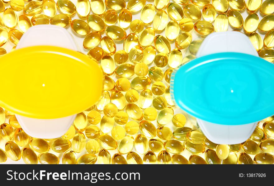 Lots of yellow pills (capsules) and two colorful cans