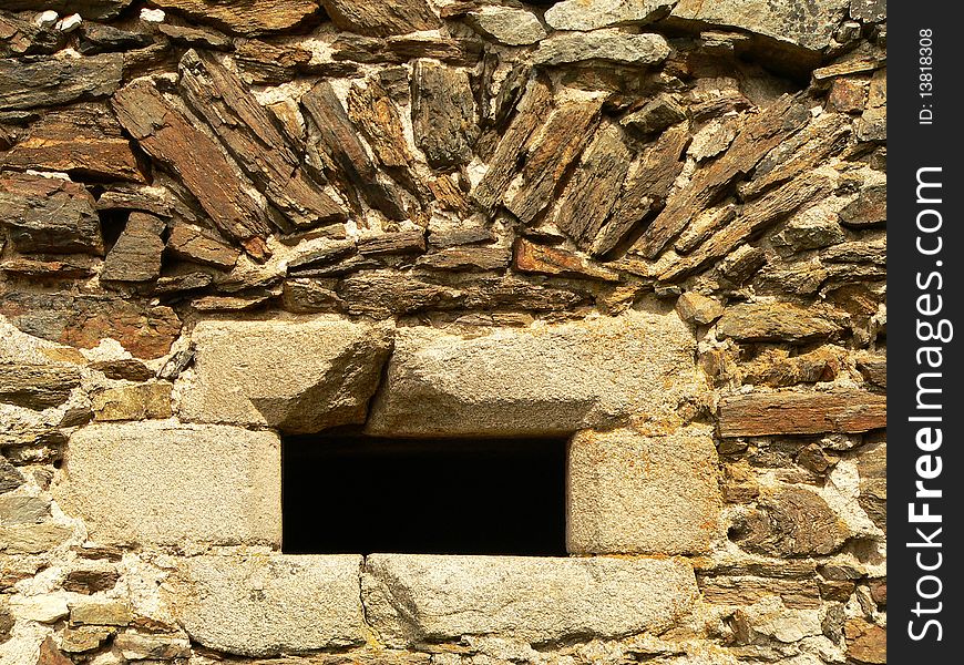 Small little window in the old stone wall