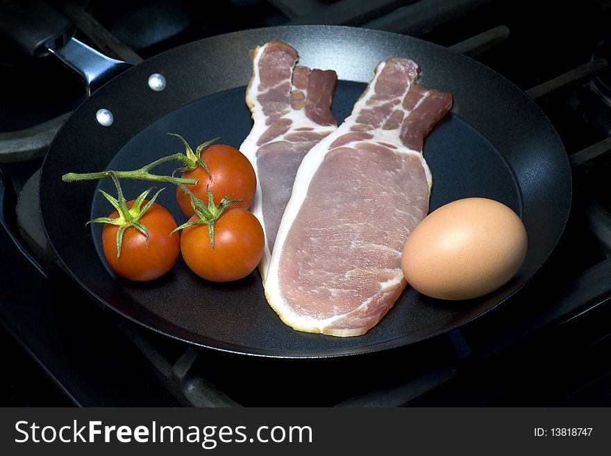 Ingredients For A Traditional English Breakfast, Egg, Bacon and Tomato In Frying Pan