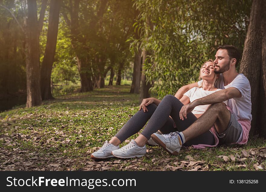 A lovely couple cuddling in a park with copy space