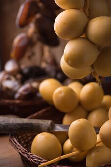 Fresh Yellow Dates On A Sprig In Wicker Plate On Rustic Wooden Background With A Knife. Close Up Side View. Low Key, Selective Stock Photography