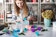 Flower Shop: Florist Girl Collects A Bouquet Of Red Roses In A Blue Paper Basket. Stock Image