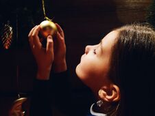 Little Girl Holding Christmas Decoration On The Christmas Tree In Her Hand Stock Images