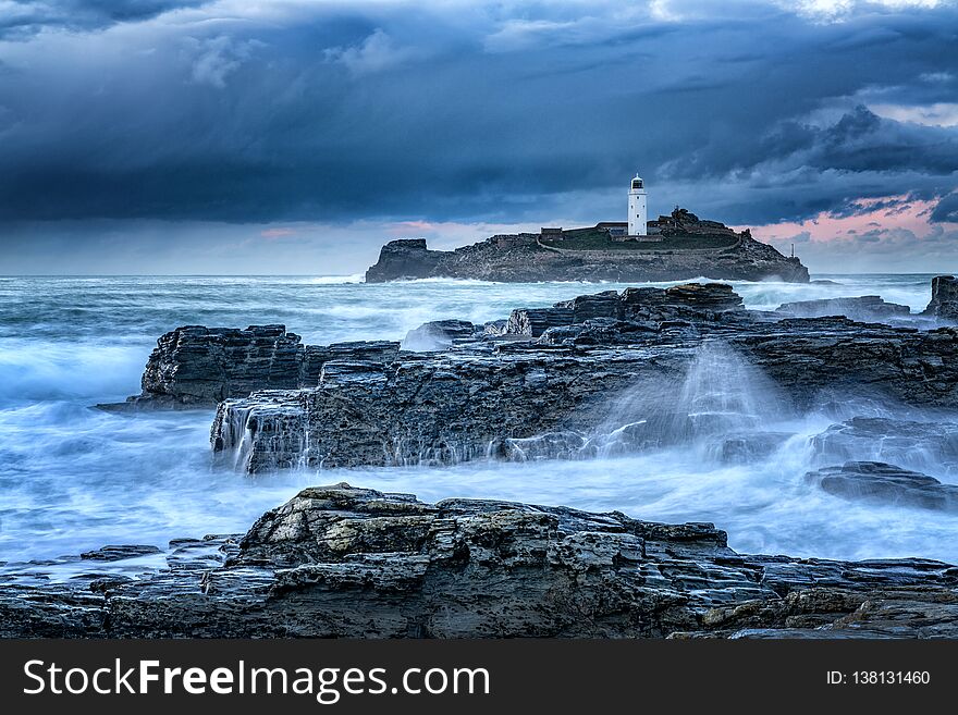 Cornish Seascape Godrevy Lighthouse at sunset as the sea crashes in