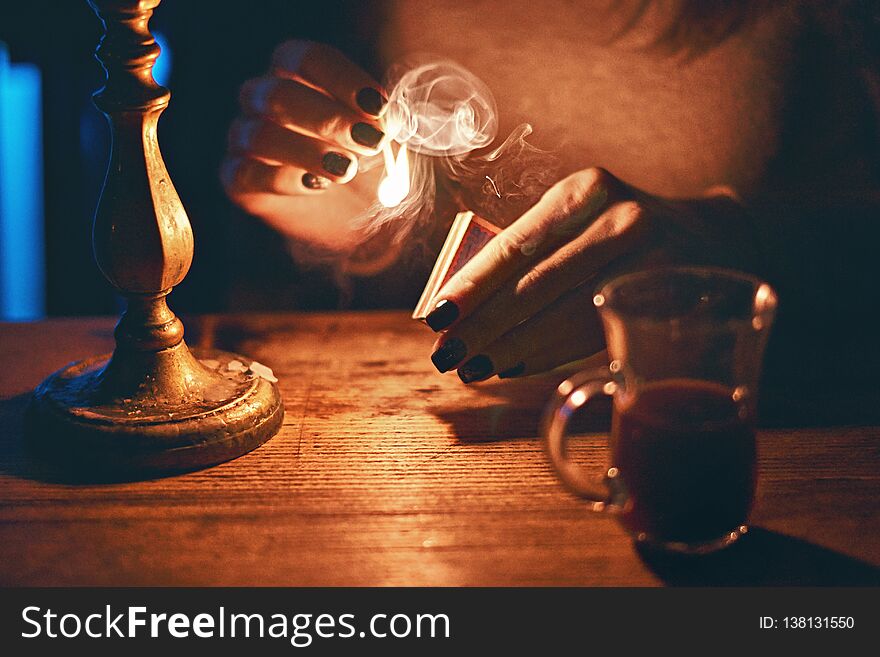 Young beautiful fortune teller woman in a mysterious setting with coffee and candles. Young beautiful fortune teller woman in a mysterious setting with coffee and candles