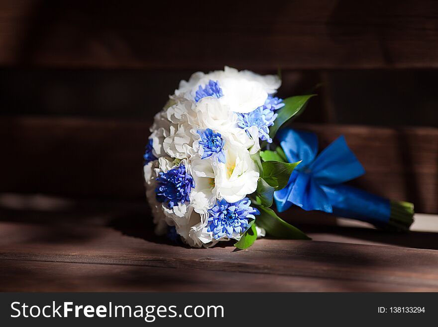 Mockup bouquet with delicate flowers and green leaves on a black background. blue ribbon