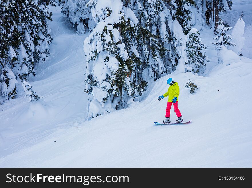Happy girl snowboarder having fun in the winter ski resort.