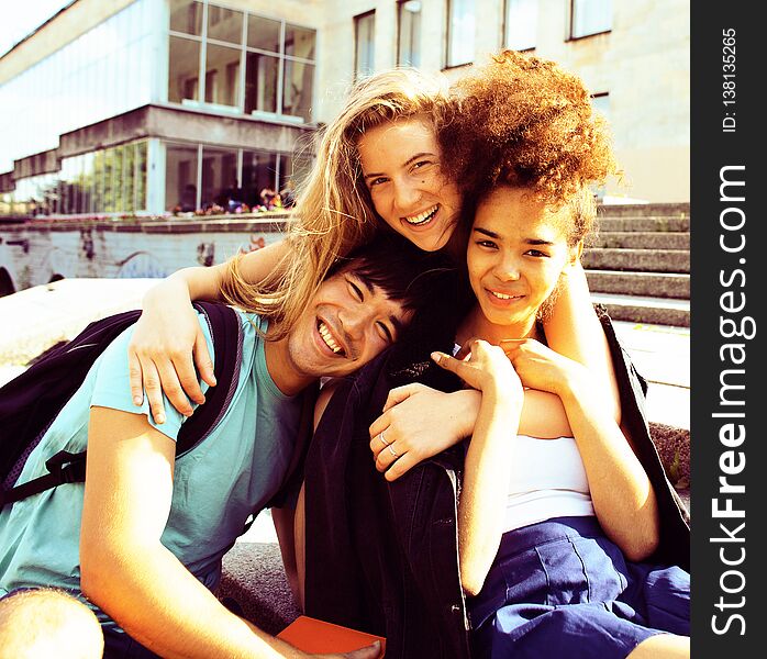 Cute group of teenages at the building of university with books huggings, back to school. Cute group of teenages at the building of university with books huggings, back to school