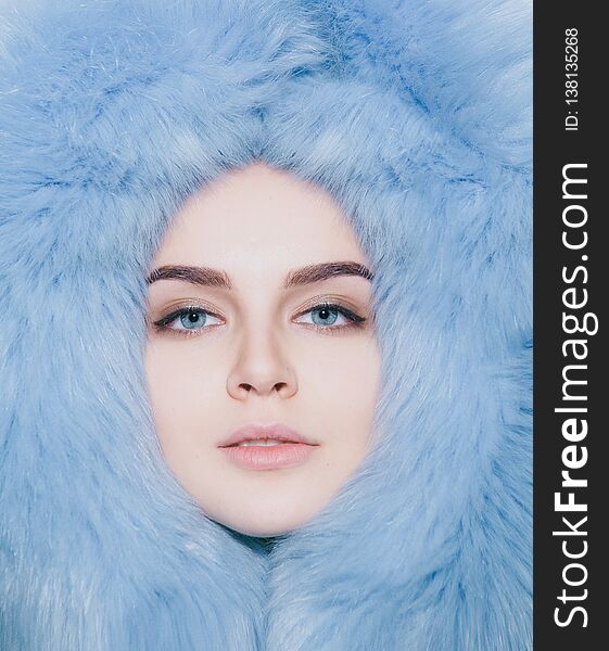 Face girl contented in soft fur coat with a hood. Face girl contented in soft fur coat with a hood