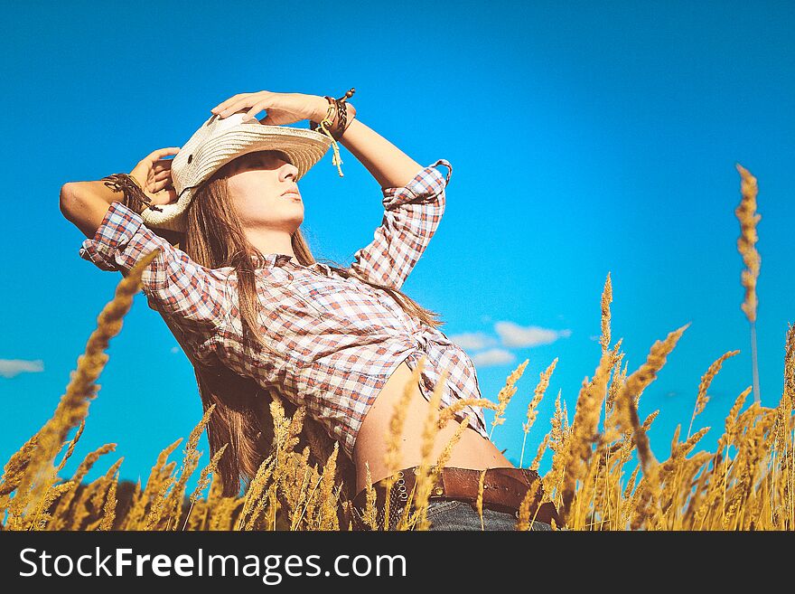 Girl dressed cowboy style outside on the field. Girl dressed cowboy style outside on the field