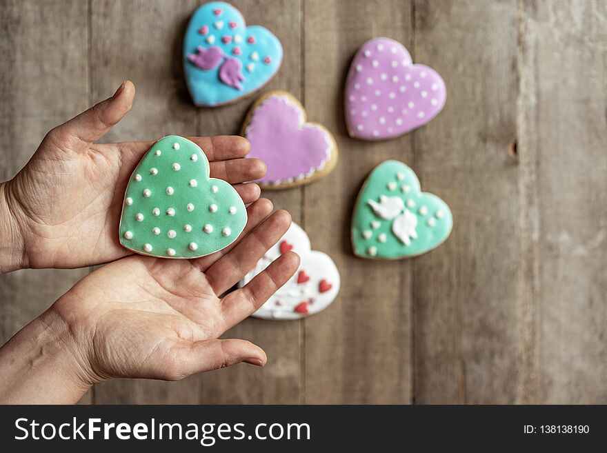 Closeup Of Cookies Heart In Glaze In The Hands Of A Woman