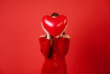 Free Young Charming Girl With Long Curly Hair, In Red Dress Holding Air Balloons, Posing At Camera. Royalty Free Stock Photography - 138163157