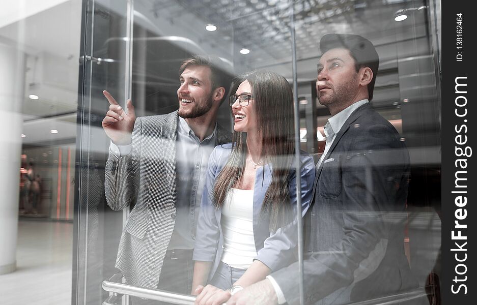 Group of business people standing in glass Elevato