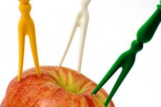 Three Colorful Forks In The Apple Royalty Free Stock Photography