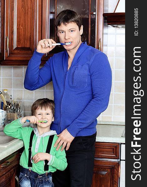 Happy father with his son brushing their teeth at home. Happy father with his son brushing their teeth at home.