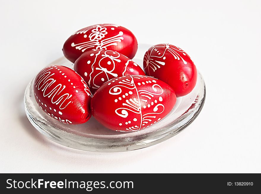 Red Easter eggs on a glass plate on white background. Red Easter eggs on a glass plate on white background