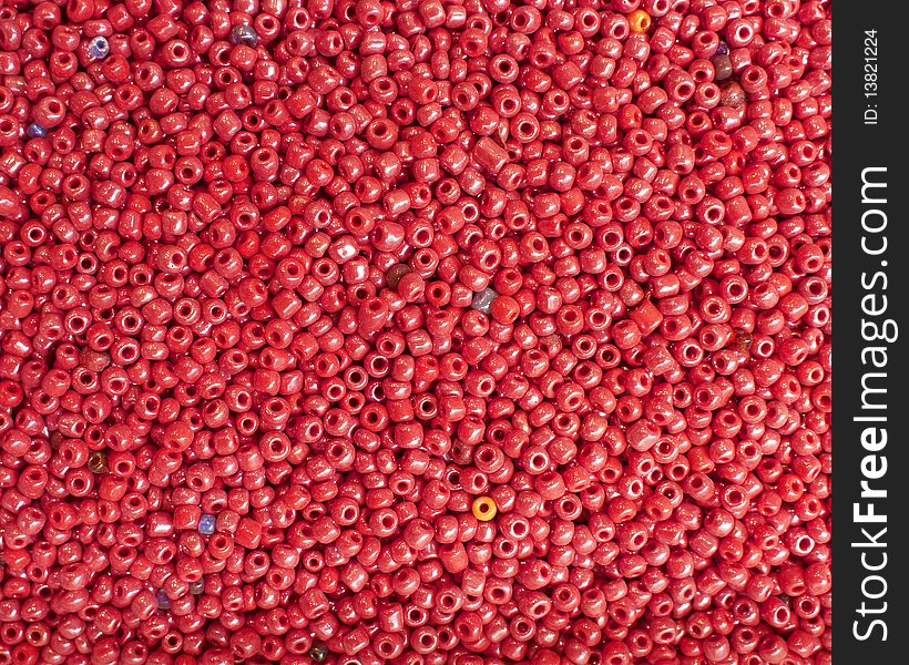 Colorful fake beads, ruby red background