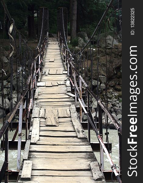 Old bridge with patches over Himalayan mountain river. Old bridge with patches over Himalayan mountain river.