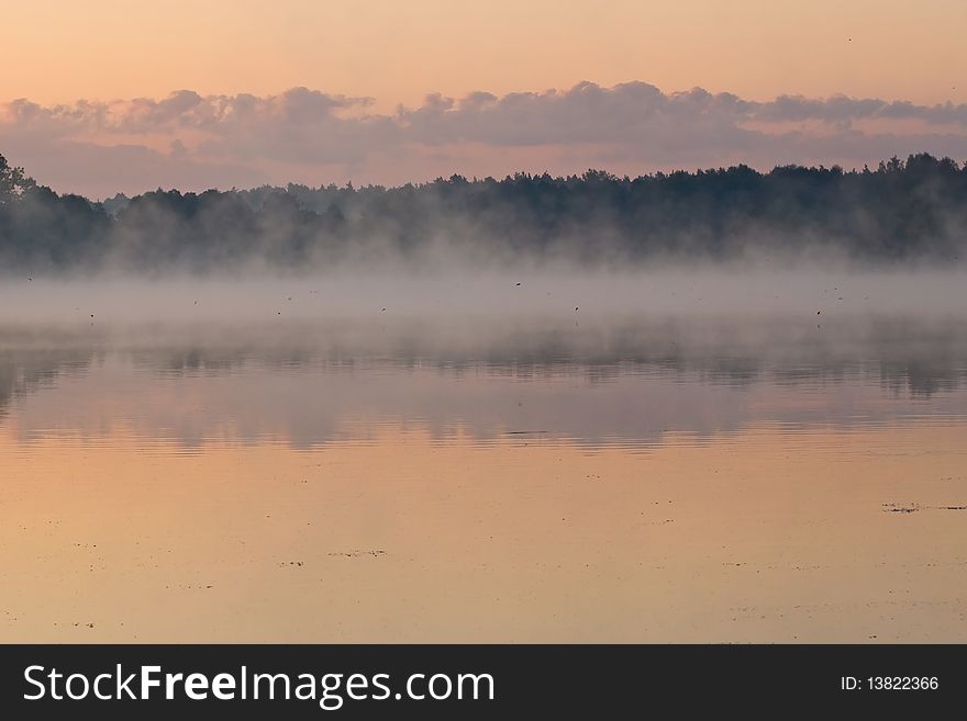 Sunrise over lake in fog