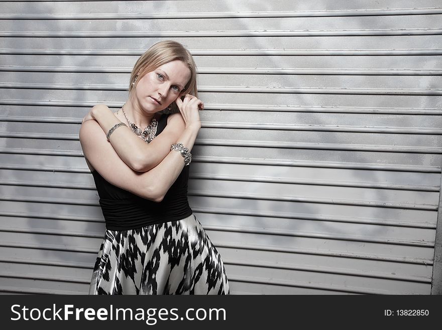 Young woman posing on a metallic background