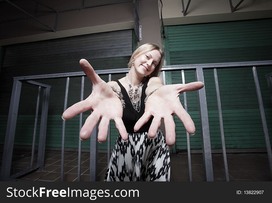 Attractive young woman reaching out her hands towards the camera and smiling