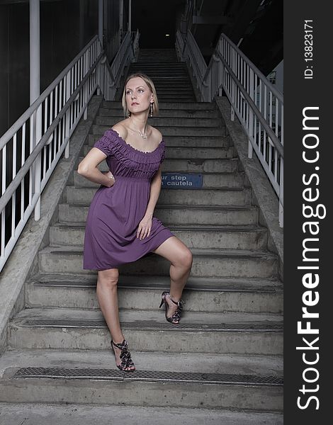 Attractive young woman posing on a staircase at night. Attractive young woman posing on a staircase at night