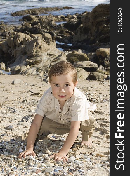 Boy at the beach playing with stones