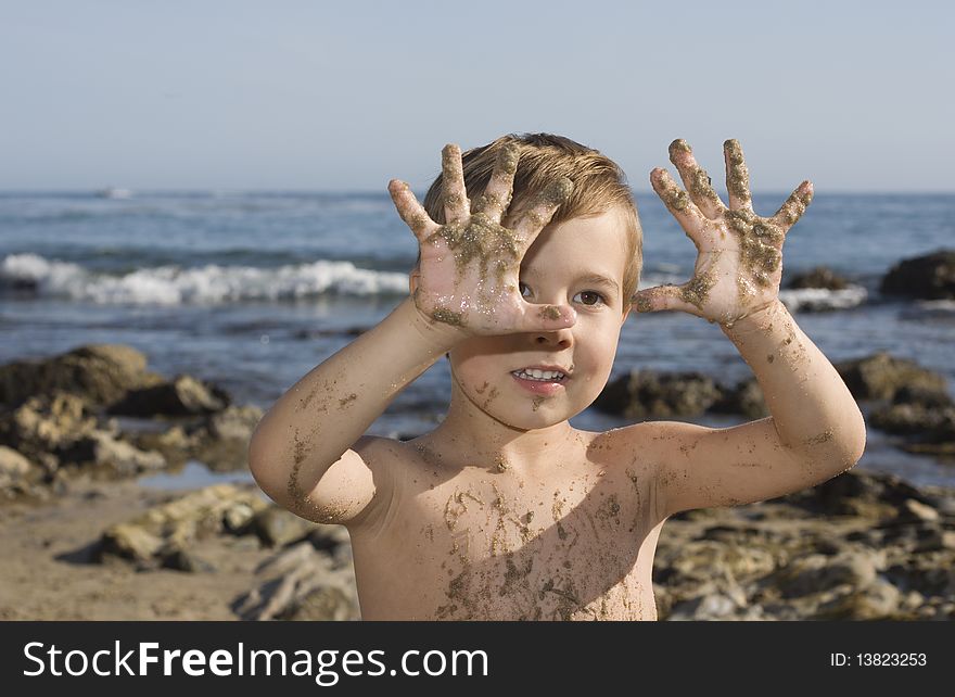 Boy at the beach playing with sand