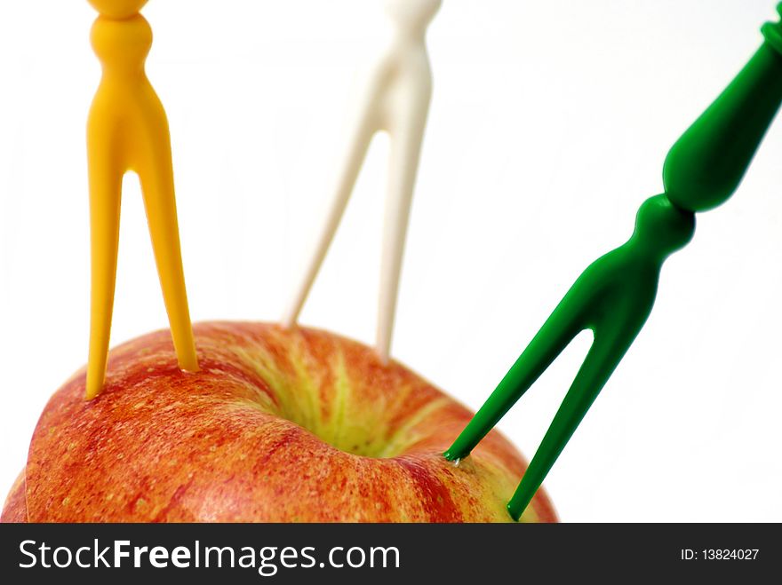 Three colorful forks in the apple isolated on the white background