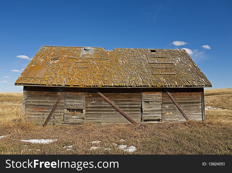 Old shack in field with blue sky background