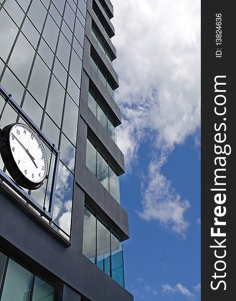 Office building and clock on the blue sky background.