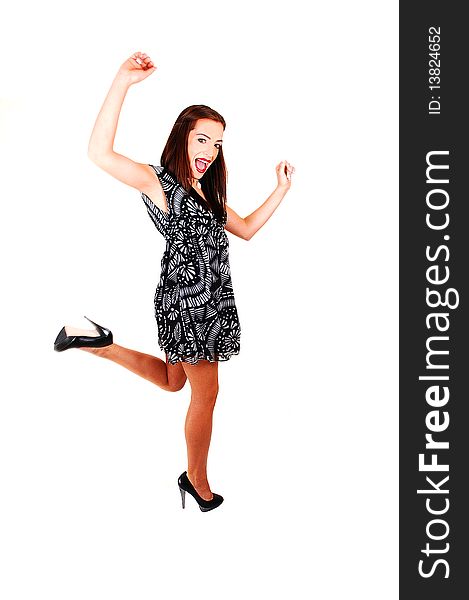 A young woman dancing in the studio for white background in a black white dress, brunette hair and high heels. A young woman dancing in the studio for white background in a black white dress, brunette hair and high heels.