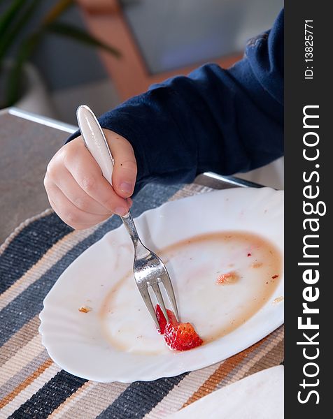 Youngster eating strawberries with maple syrup. Youngster eating strawberries with maple syrup