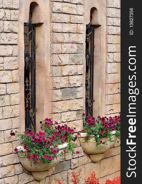 Two windows and small parterre or basket of flower, decorated on external wall of a castte building, with beautiful shape and harmonious color. Two windows and small parterre or basket of flower, decorated on external wall of a castte building, with beautiful shape and harmonious color.