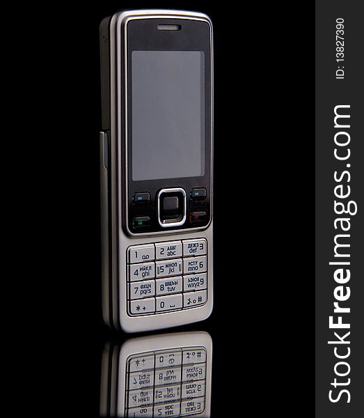 Grey isolated mobile phone over black background