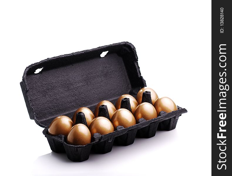 Gold eggs in a black carton on white background