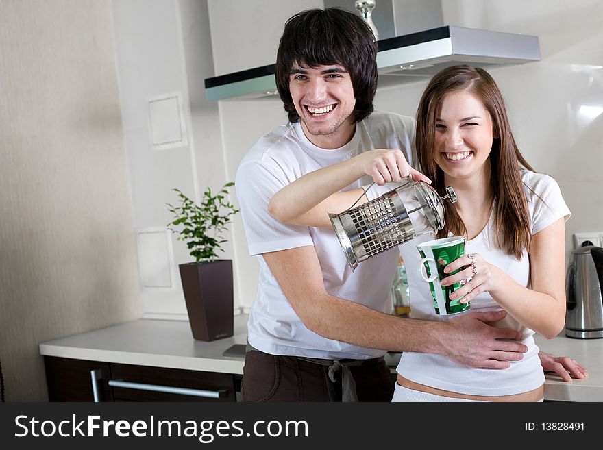 Boy with smile and beautiful girl with cup and with teapot. Boy with smile and beautiful girl with cup and with teapot