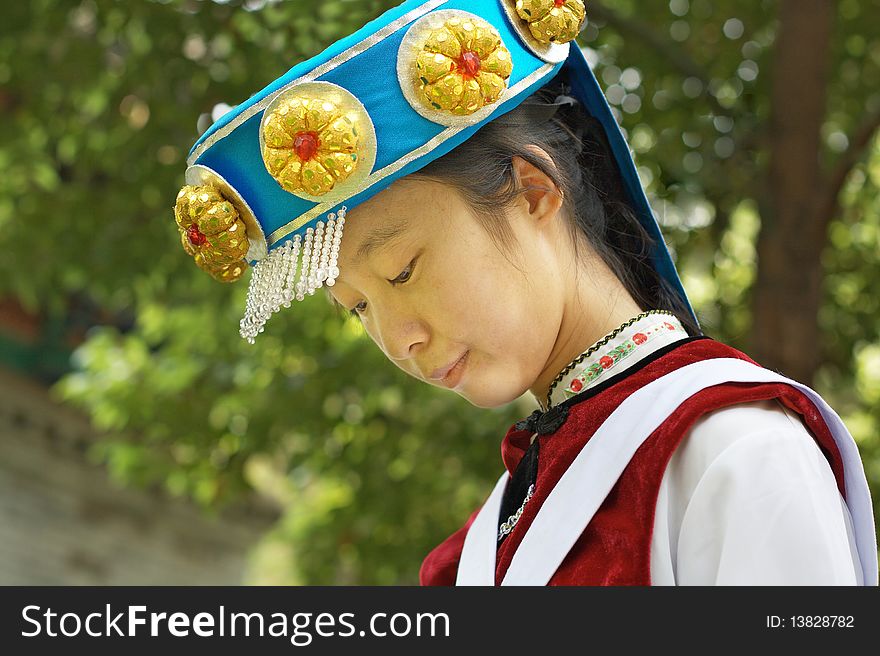 A pretty Chinese woman wearing the traditional clothes of the Naxi cultural minority. A pretty Chinese woman wearing the traditional clothes of the Naxi cultural minority