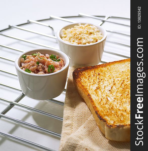 Two small bowls of scrambled eggs and minced meat as ingredients for toasted sandwich. Two small bowls of scrambled eggs and minced meat as ingredients for toasted sandwich.