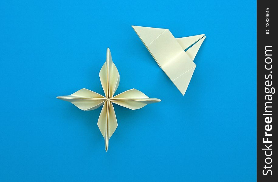 Origami flower with a butterfly on a blue background. Origami flower with a butterfly on a blue background