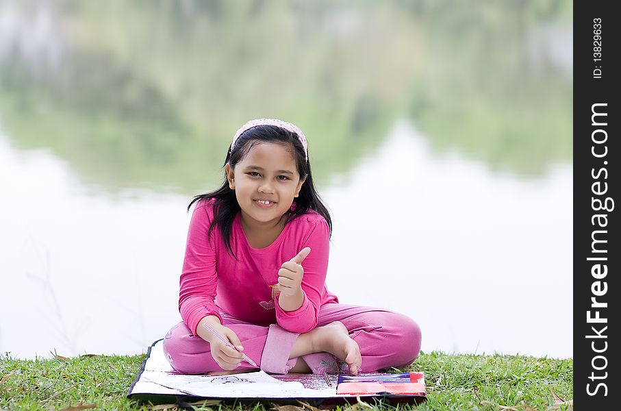 A girl is making schoolwork at the park. A girl is making schoolwork at the park