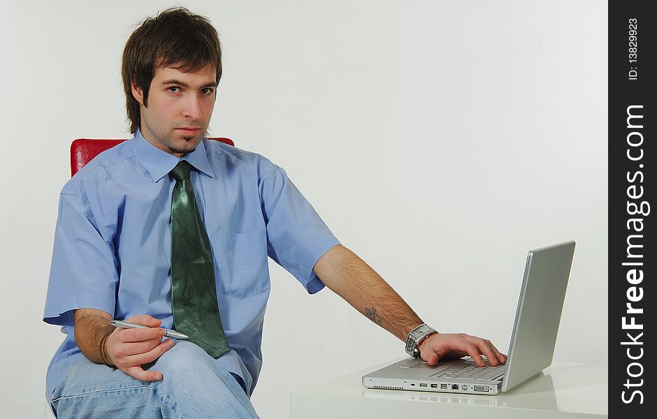 Young man using a laptop while sitting on the floor. Young man using a laptop while sitting on the floor