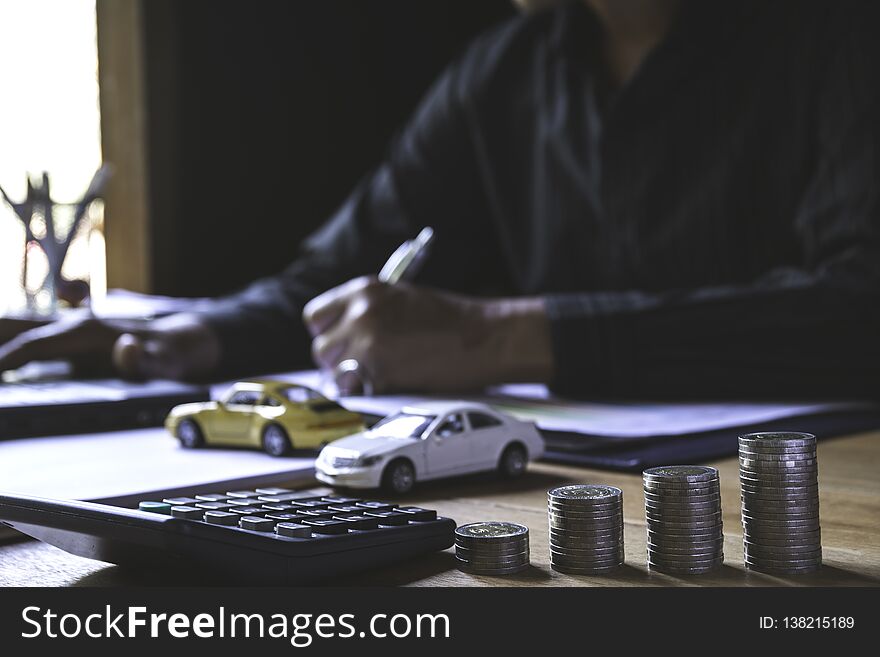 Car insurance and car service. Businessman with stack of coins and toy car, business and financial concept